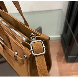 Detail shot of a stylish brown women shoulder bag featuring metallic buckle and fine stitching.