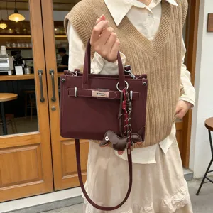 Stylish wine red women's shoulder bag with metal lock and cute dachshund charm for daily use.