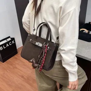 Stylish women brown small square shoulder crossbody bag with cute dog pendant and lock design.