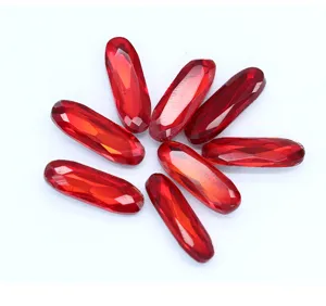 Vista detallada de estras de vidrio de cristal ovalado largo rojo, gemas DIY brillantes.
