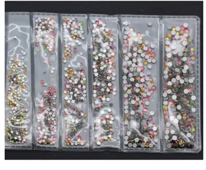 Vista dettagliata di strass in vetro piatti assortiti in confezione trasparente per nail art.