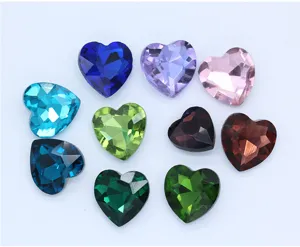 Heart-shaped crystal glass rhinestones closeup, colorful faceted diamond gems for DIY crafts.