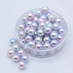 Perle artificiali ABS sfumate colorate in un contenitore trasparente per bigiotteria.
