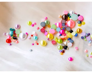 Gros plan de perles demi-rondes colorées et d'accessoires de nail art, vue détaillée.