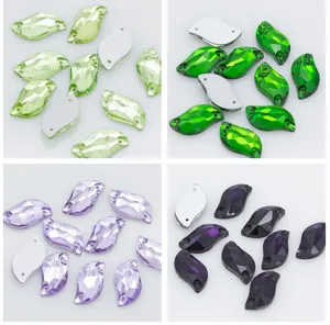Gros plan détaillé de strass en verre en forme de feuille S colorée avec deux trous de couture.