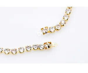 Gold plated rhinestone claw chain connector DIY jewelry making accessory detail close up.