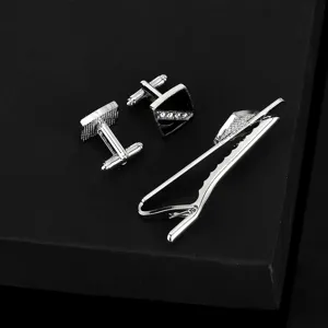 Gros plan de boutons de manchette argentés pour hommes et pince à cravate avec strass.