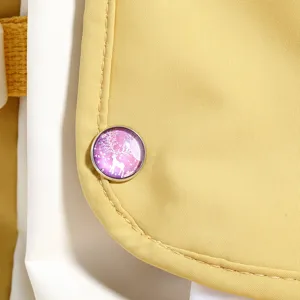 Detailed close-up of a cute sika deer time gem metal brooch badge on yellow fabric.