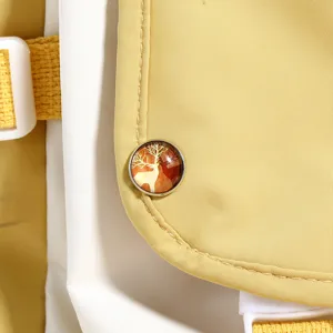 Detailed view of yellow white colorblock backpack with cute deer metal badge accent.