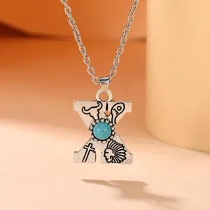 Detailed view of the bohemian letter X turquoise alloy necklace, vintage western pendant.