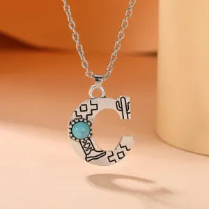 Bohemian style letter C pendant necklace with turquoise stone and western cowboy elements.