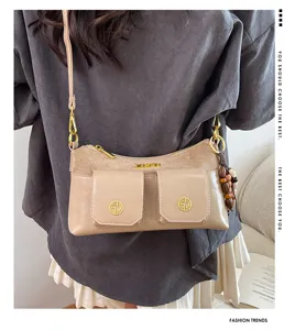 Vue détaillée du sac à bandoulière chic à poches multiples, empiècement suédé et détails dorés.