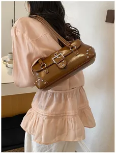 Bolso de hombro marrón de charol para mujer con hebilla metálica y remaches.