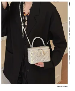 Silver quilted chain crossbody bag detail with metallic studs and elegant pearl decor.