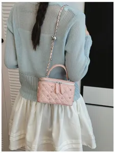 Chic pink quilted vanity crossbody bag with rhinestones, pearls and chain strap for women.