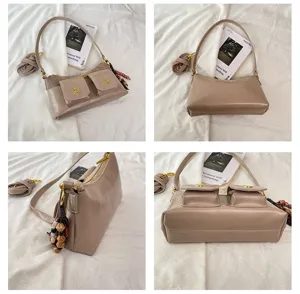 Élégant sac à bandoulière multi-poches avec pendentif en perles pour femme et usage quotidien.