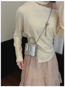 Detailed close-up of a silver quilted chain vanity crossbody bag with elegant metal strap.