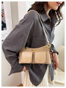Sac à épaule chic à poches multiples avec empiècement suédé et pendentif perlé.