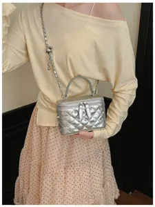 Crossbody quilted silver vanity bag with chic chain strap and pearl studs for women.