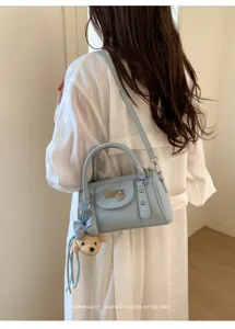 Casual light blue bowling shoulder bag for women, stylish commute pillow handbag with cute bear pendant.