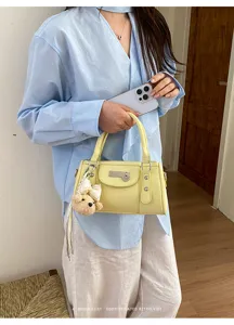 Trendy rivet hand-held pillow bag for women, casual commuter bowling bag with chic charm.
