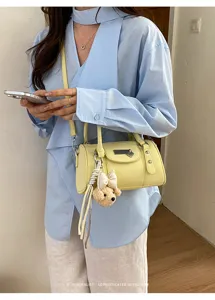 Trendy yellow pillow bag with cute bear charm, versatile commuter shoulder crossbody bag.