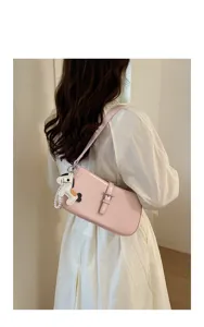 Vue détaillée du sac porté épaule rose pour femme avec charm cheval et boucle chic.
