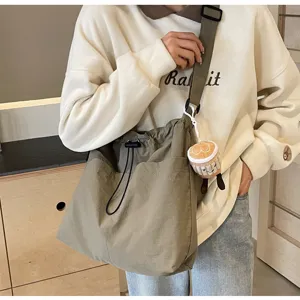 Large capacity casual canvas shoulder bucket bag with wide strap for daily commute and travel.