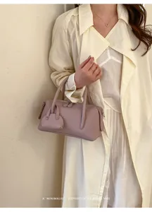 Stylish litchi pattern boston pillow bag detail, featuring premium leather and sturdy handles.