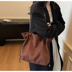 Vue détaillée du sac porté épaule en suédine marron avec chaîne et cordon de serrage élégant.