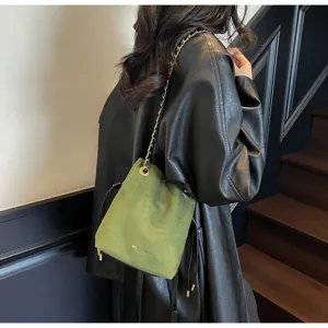 Sac seau en daim vert vue de détail montrant la bandoulière chaîne et texture douce.