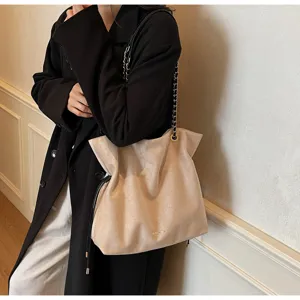 Vue détaillée d'un sac porté épaule en suédine beige avec chaîne, style élégant.
