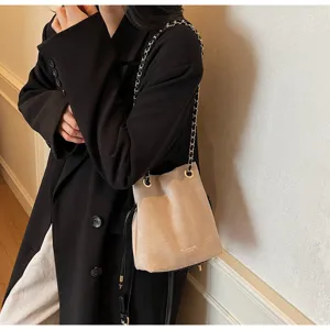 Sac seau élégant en suédine kaki avec bandoulière chaîne pour un look automnal chic.