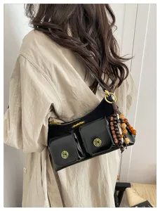 Vue détaillée du sac porté épaule noir à poches multiples avec perles en bois.