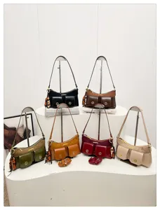 Vue détaillée du sac à bandoulière tendance à multi-poches avec accessoires en métal.