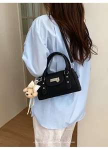 Black rivet bowling bag with cute teddy bear pendant, stylish retro commuter shoulder handbag.