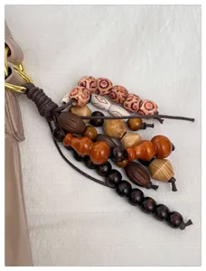 Vue détaillée du sac bandoulière élégant pour femme avec pendentif en perles de bois.