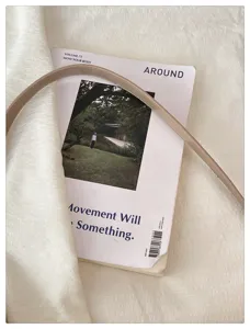Détail de sac à bandoulière en cuir beige minimaliste, sac chic de navette sous les bras.