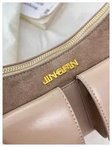 Gros plan du sac à aisselles élégant à poches multiples avec logo en métal.