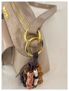 Vue détaillée d'un sac à épaule tendance en cuir PU avec pendentif en perles de bois.