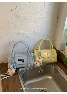 Detailed view of the stylish retro bowling bag featuring chic metal lock and cute bear charm.