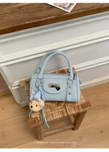 Light blue bowling bag detail, retro style shoulder bag with cute bear charm and metal rivets.
