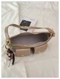 Sac à bandoulière beige multi-poches pour femmes, sac hobo chic de navette avec pendentif perlé.