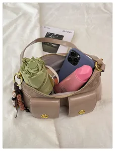 Gros plan sur l'intérieur de sac à bandoulière tendance avec poches multiples.