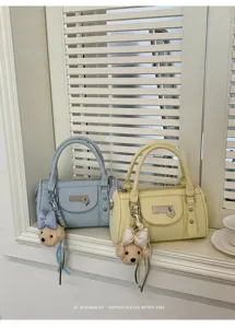 Trendy rivet bowling handbag for women, chic pillow shoulder bag with cute bear charm.