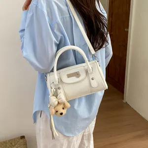 Trendy white shoulder bowling bag for women, chic pillow handbag with cute puppy charm.