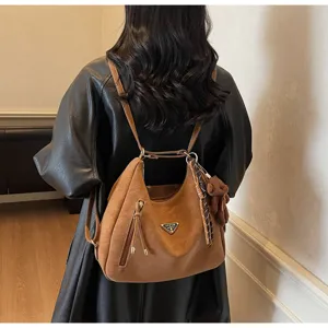 Brown leather multi-use backpack detail, stylish hobo shoulder bag with bear pendant and zip pocket.