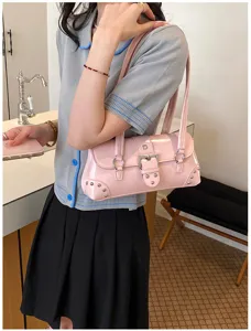 Detalle de bolso de hombro de charol rosa con hebilla metálica y tachuelas geniales.