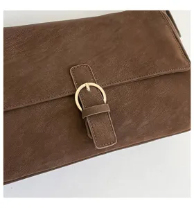Brown retro handbag detail shot, vintage PU leather shoulder bag with metal buckle accent.