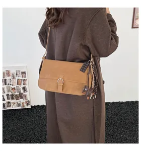 Retro brown shoulder bag for women, stylish underarm crossbody bag with chic charms.